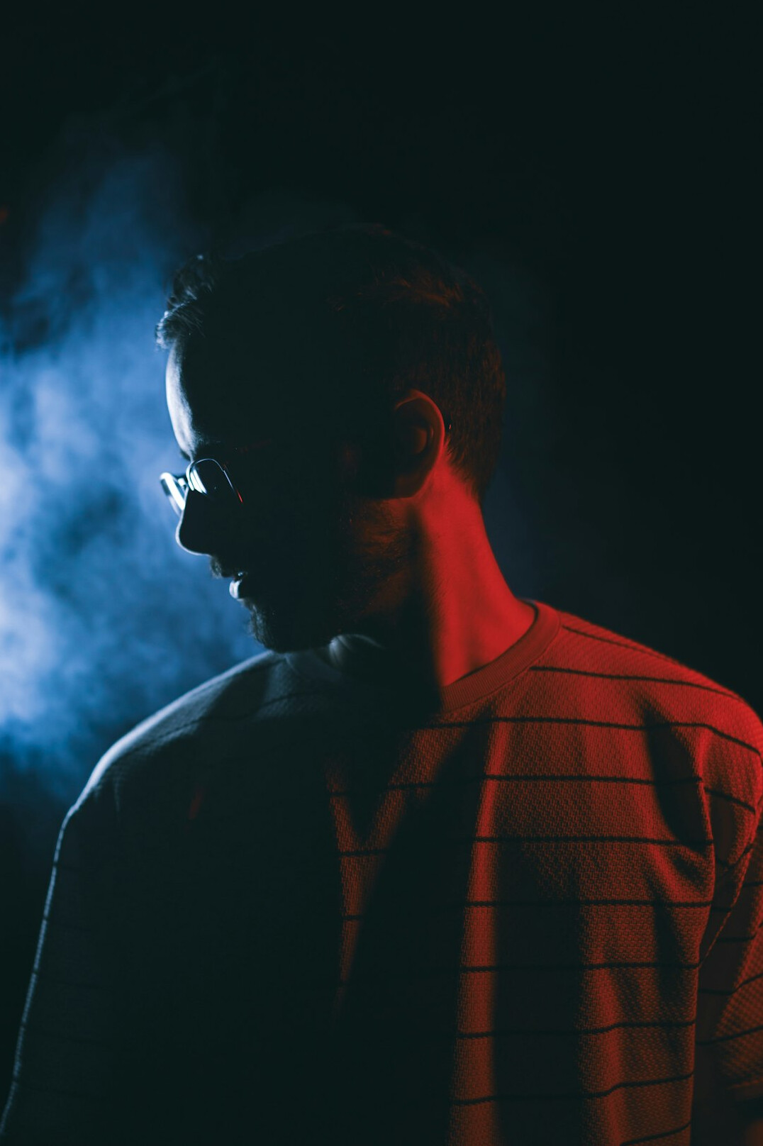 Studio portrait of a bearded man wearing glasses and a casual shirt