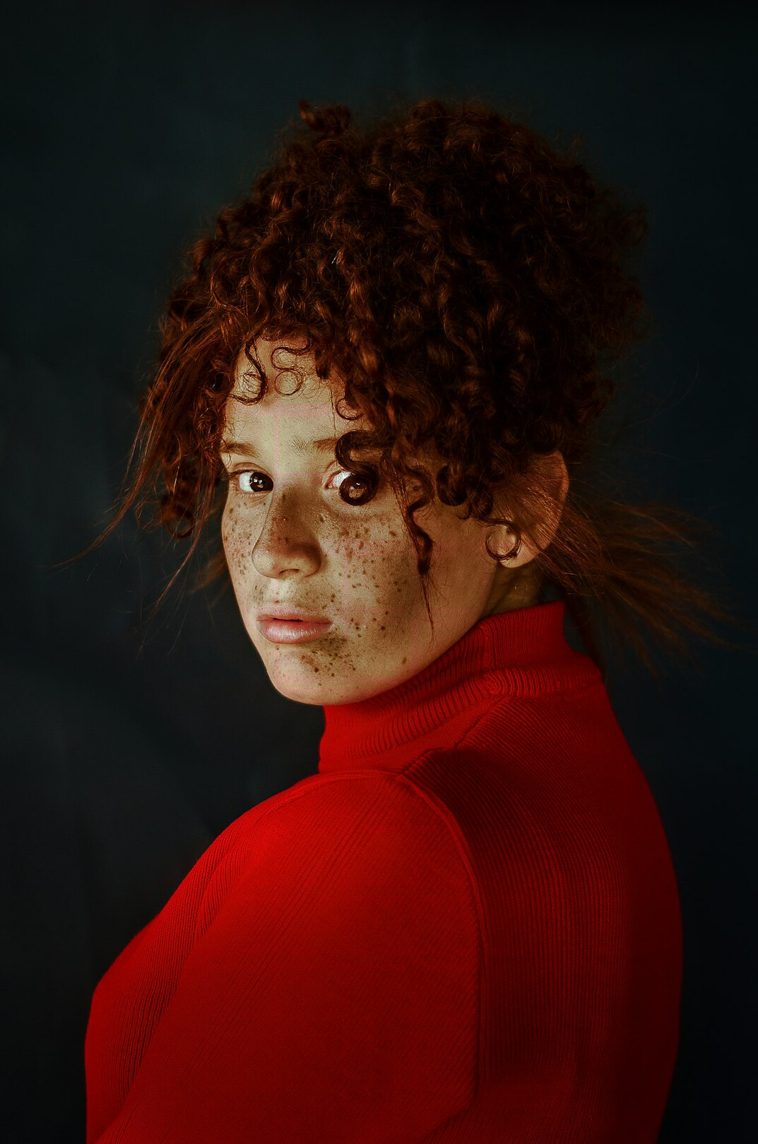 Studio portrait of a woman with red curly hair
